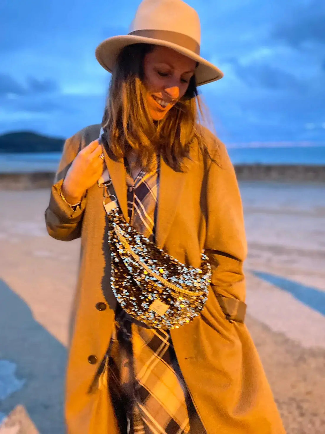 femme à la plage a saint-lunaire en hiver portant un beau chapeau et un sac banane à paillettes sequins