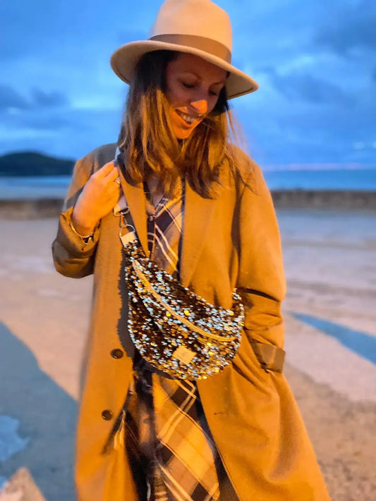 femme à la plage a saint-lunaire en hiver portant un beau chapeau et un sac banane à paillettes sequins