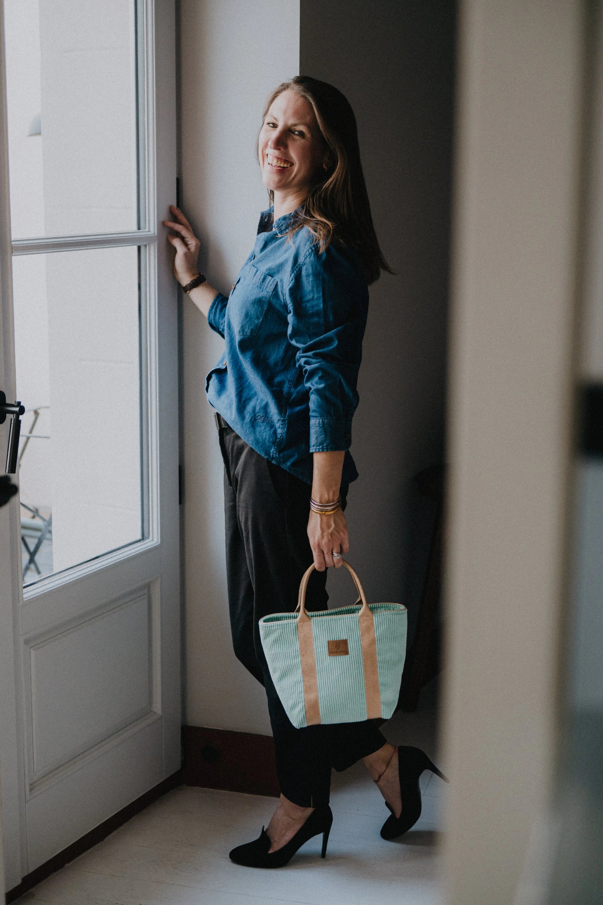 sac cabas couleur pistache femme à la fenêtre hotel